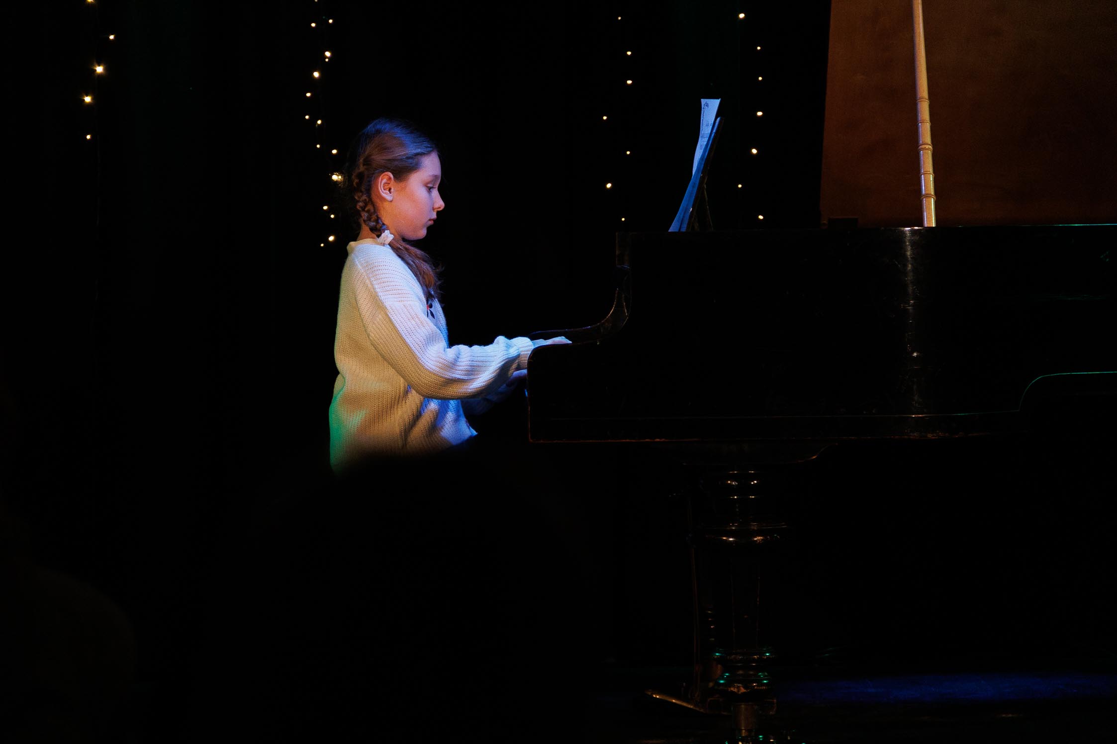 dziecko gra na fortepianie, na scenie